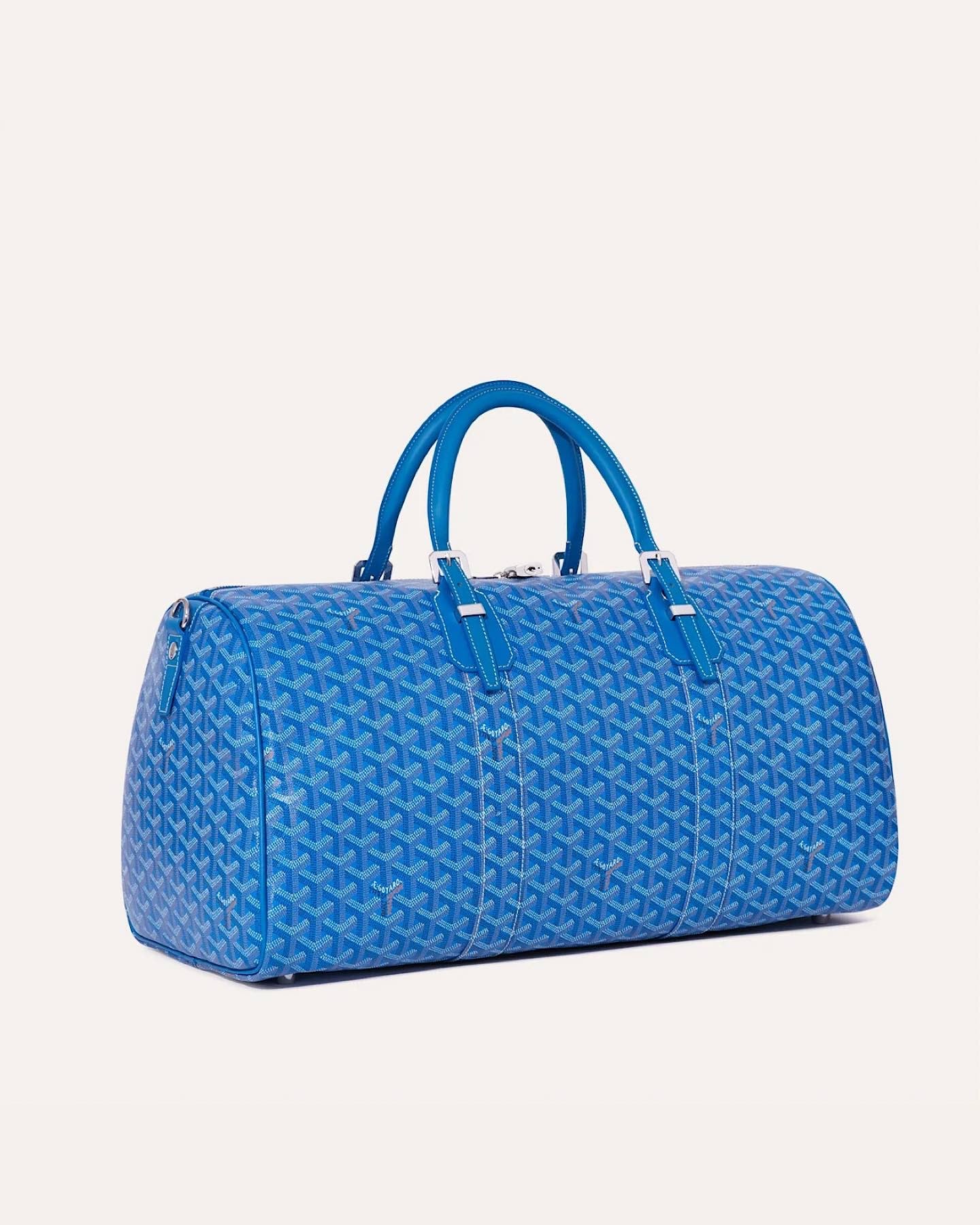 Side view of the Goyard Boston 50 travel bag in Sky Blue with leather handles.