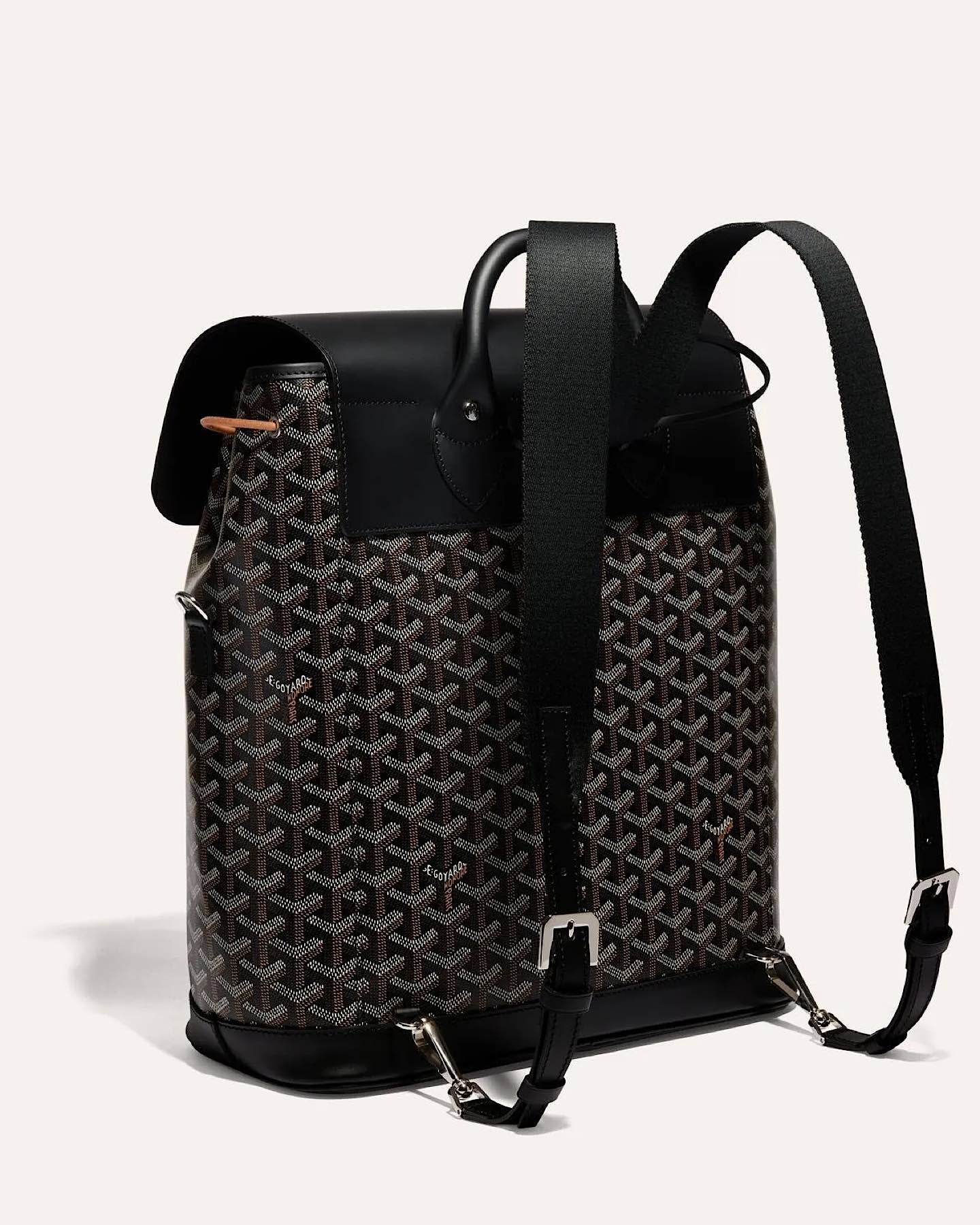 Side view of the Goyard Alpin MM Backpack in Black with adjustable leather shoulder straps.
